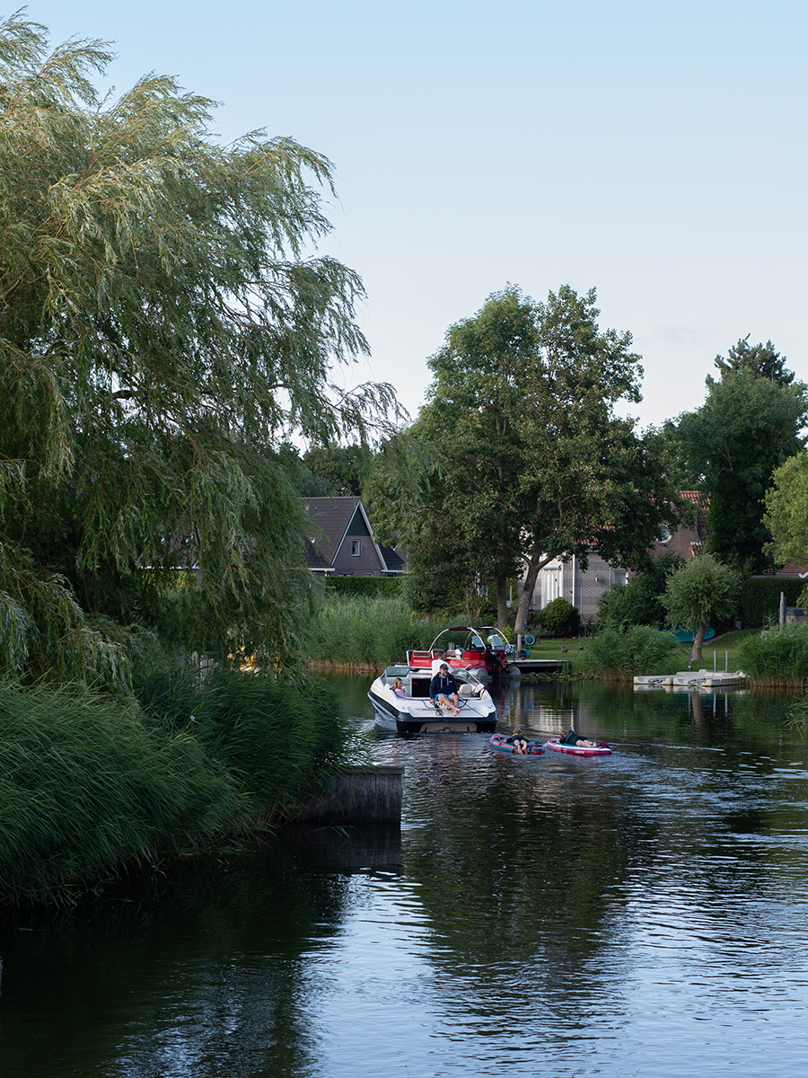 Ein Motorboot gleitet entlang einer malerischen Wasserstraße im Beach Resort Makkum am IJsselmeer in den Niederlanden