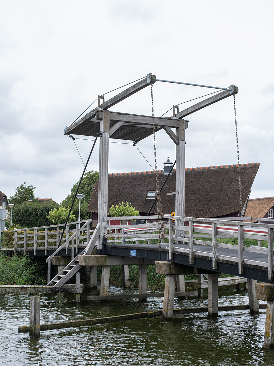 Entdecke die malerische Brücke in Makkum am Ufer des IJsselmeers in den Niederlanden, die das Land mit dem Wasser verbindet