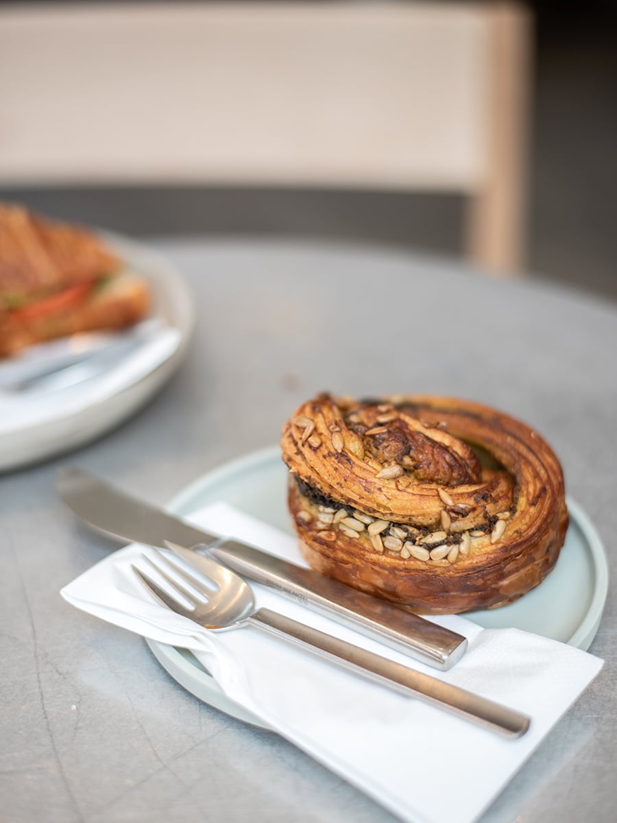 Eine Pesto-Oliven-Mozzarella-Rolle auf einem eleganten Teller mit stilvollem Besteck im Saint-Jean Deli im Jordaan-Viertel von Amsterdam