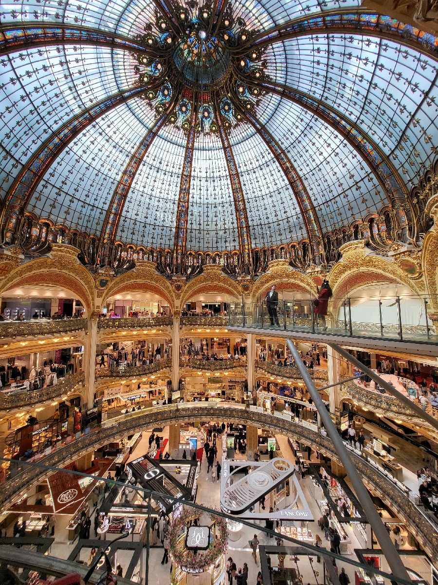 Innenansicht der Galeries Lafayette in Paris mit beeindruckender Jugendstil-Glaskuppel – architektonisches Highlight und beliebtes Fotomotiv im Pariser Kaufhaus.