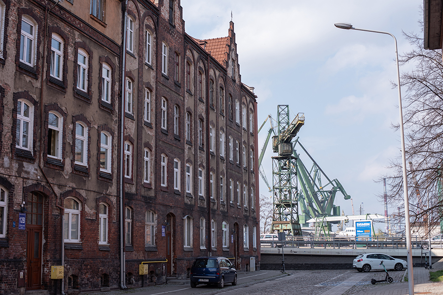 Historische Backsteinhäuser im Danziger Hafenviertel mit Kran im Hintergrund