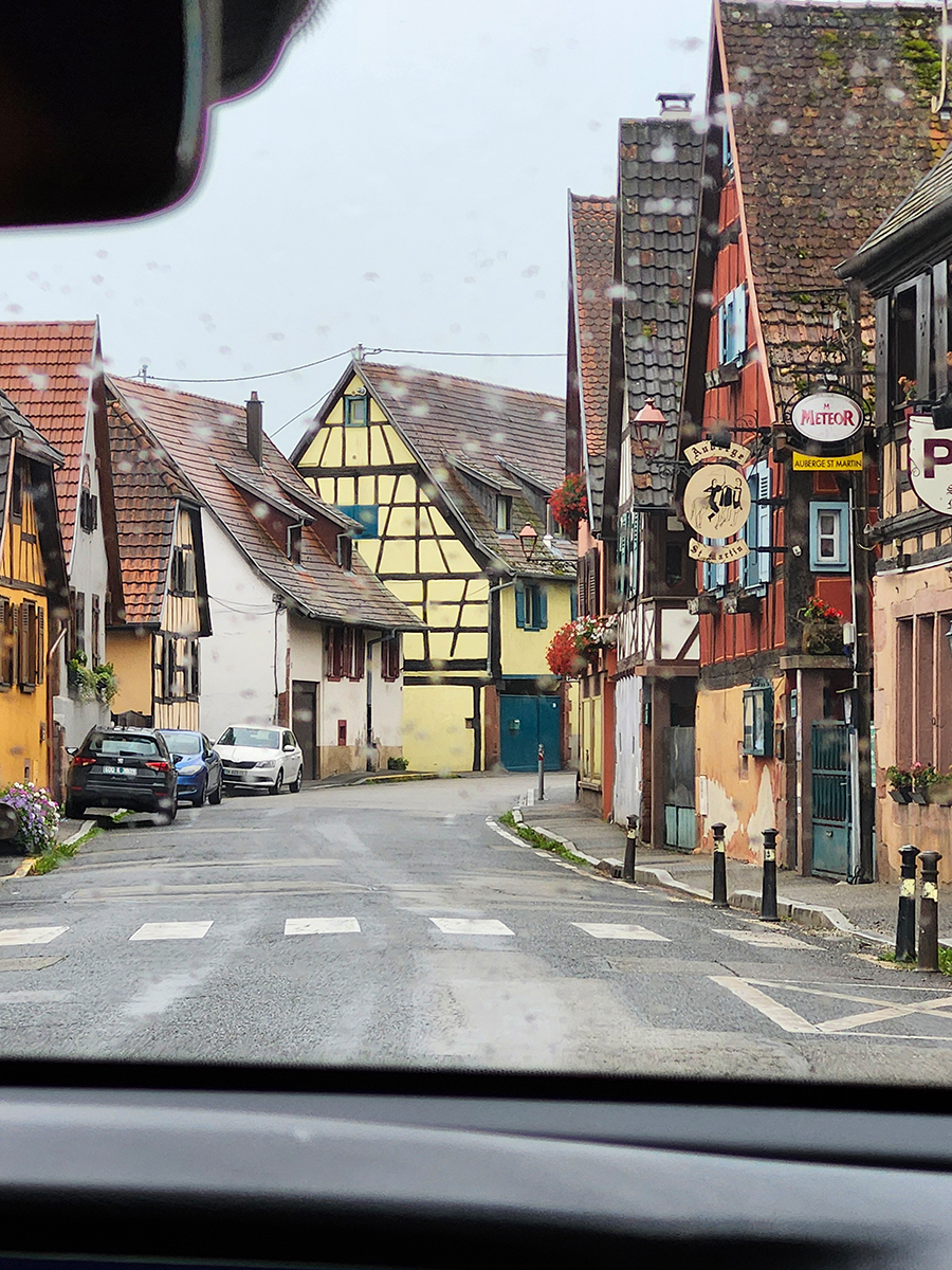 Bunte Fachwerkhäuser in einem kleinen Dorf im Elsass, fotografiert durch die Autoscheibe