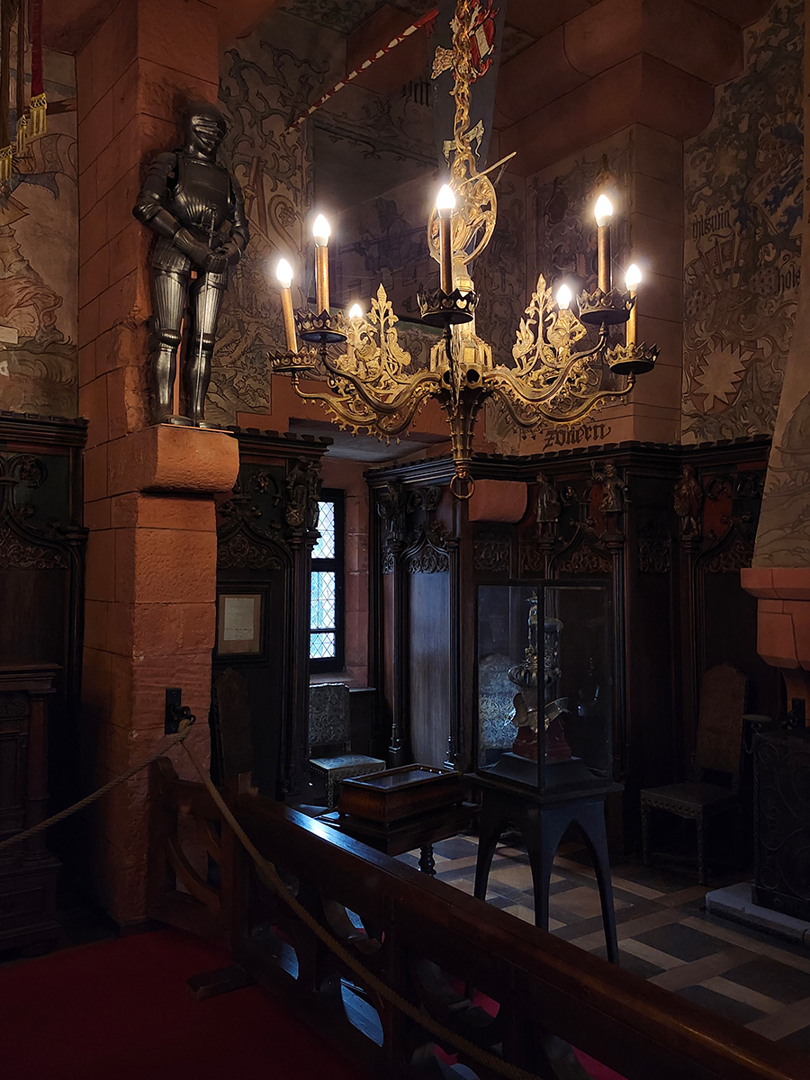 Innenraum der Hohkönigsburg mit Ritterrüstung, Leuchter und Wandmalereien