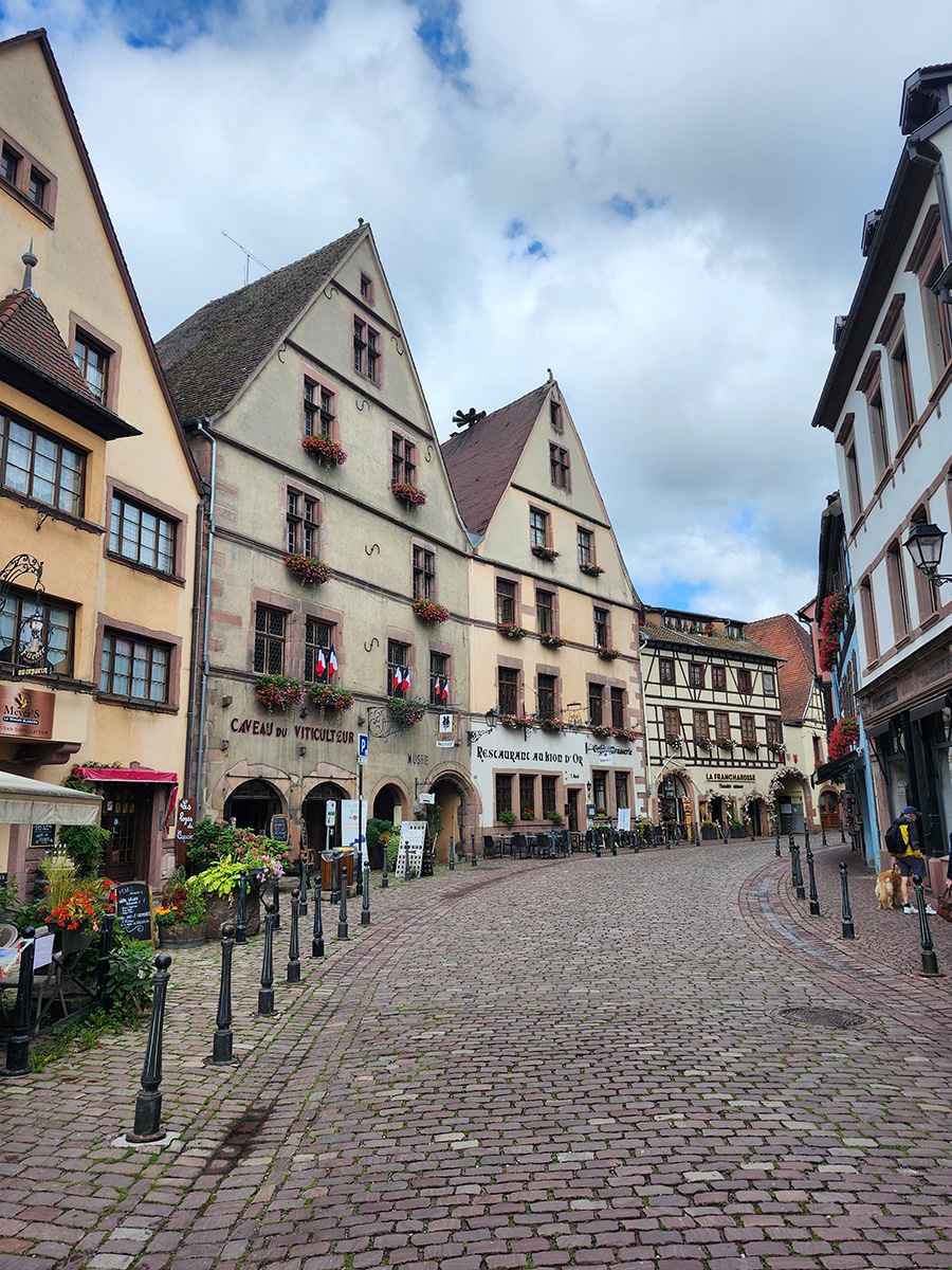 Kopfsteinpflasterstraße mit bunten Fachwerkhäusern in Kaysersberg