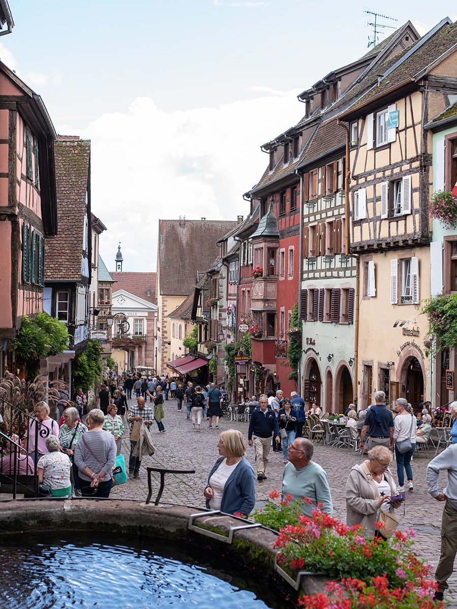 Enge Gasse mit bunten Fachwerkhäusern und Kopfsteinpflaster in Riquewihr