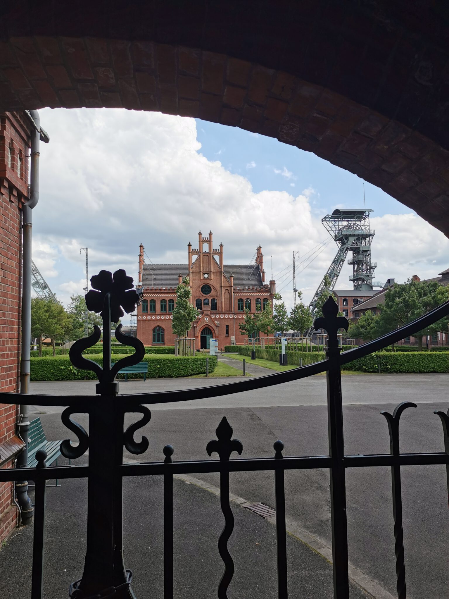 Blick durch einen Torbogen auf das LWL-Industriemuseum Zeche Zollern in Dortmund mit Förderturm