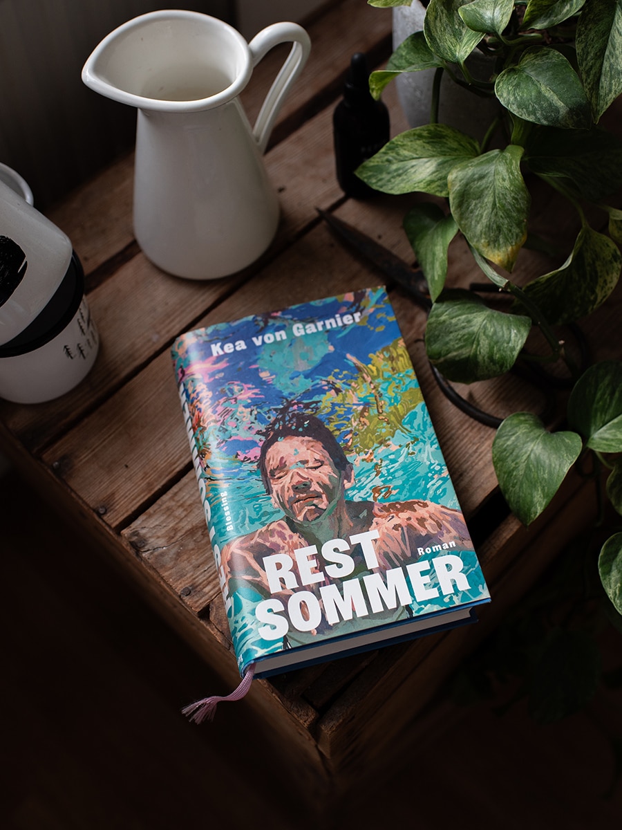 Buch „Restsommer“ von Kea von Garnier auf einem Tisch neben einer Tasse und einer Pflanze