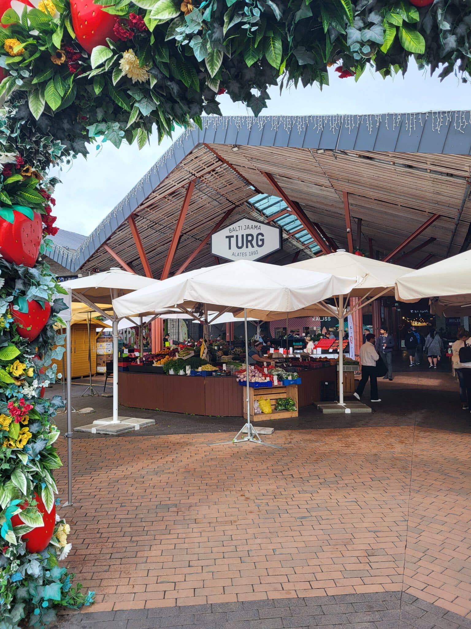 Überdachter Eingangsbereich des Balti Jaama Turg mit Marktständen und Sitzplätzen in Tallinn