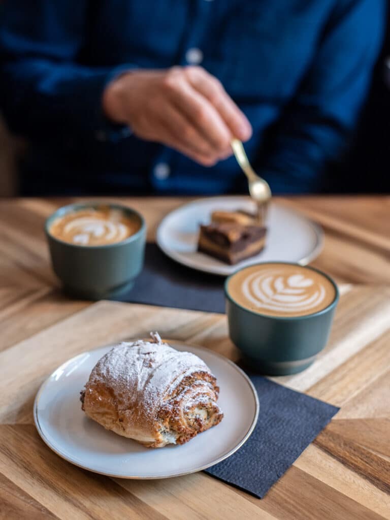 Cappuccino und Croissant auf einem Holztisch im Kiosk No. 4 in Tallinn