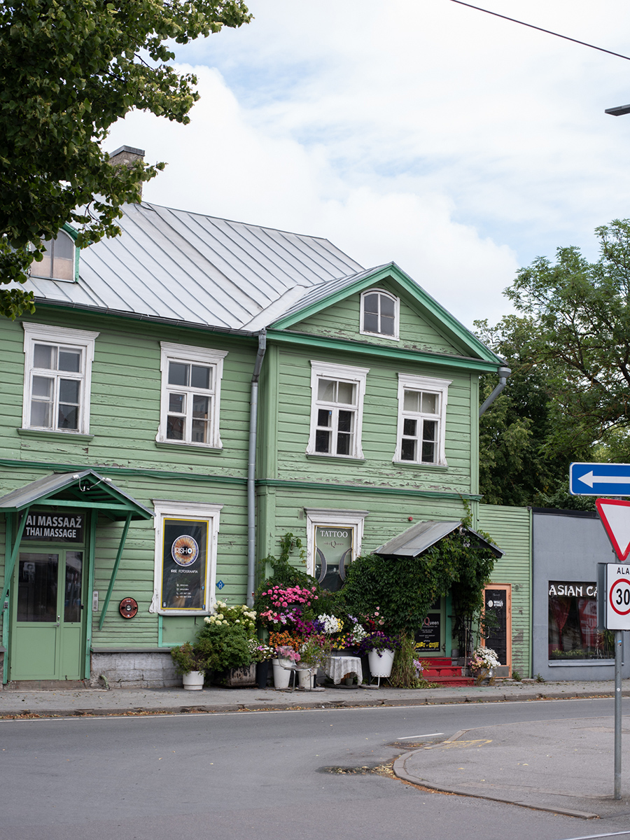 Grünes historisches Holzhaus mit Außengastronomie im Tallinner Stadtteil Kalamaja