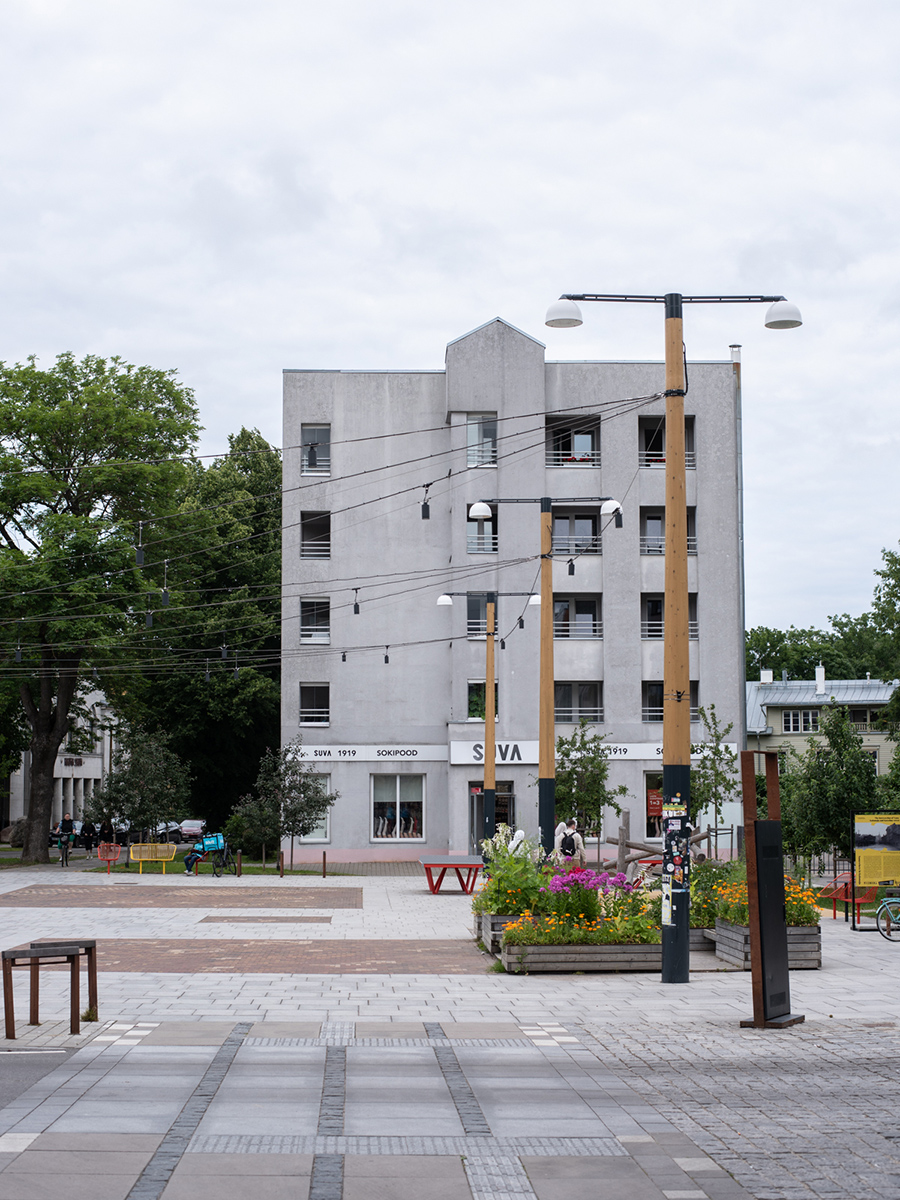 Modernes Wohngebäude an einem Platz in Tallinn mit Bäumen und Sitzgelegenheiten