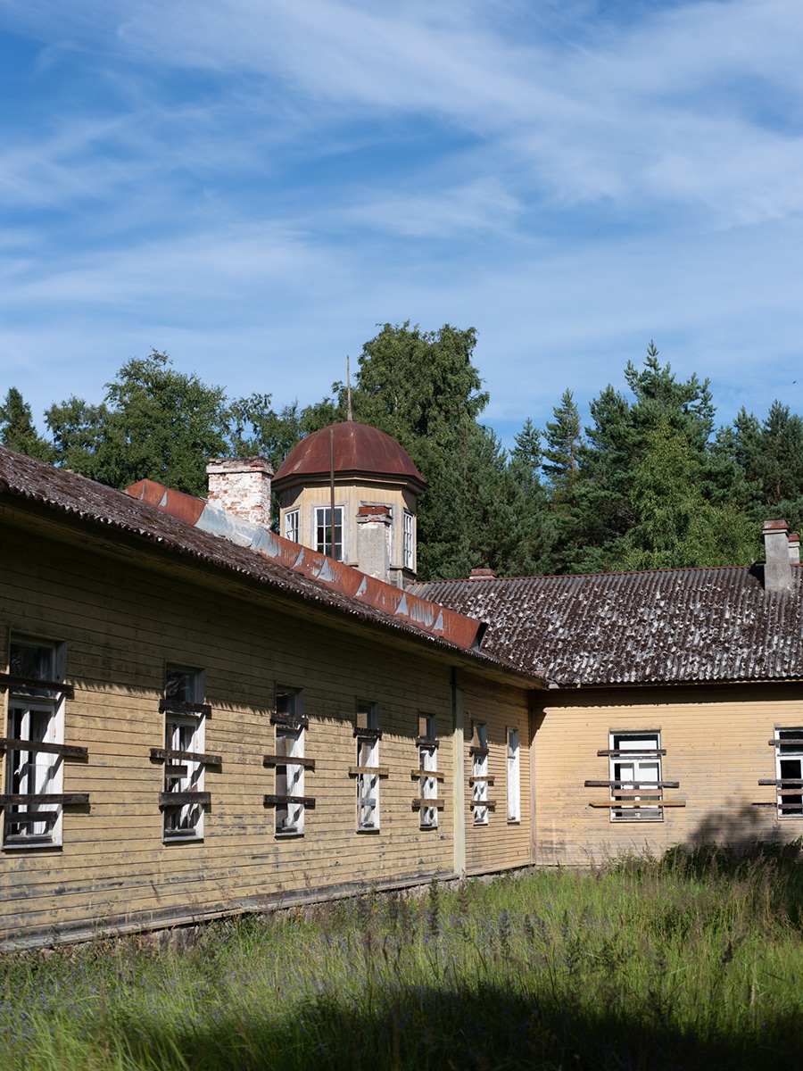Historisches Gebäude mit heller Fassade und Schornsteinen auf der Insel Aegna
