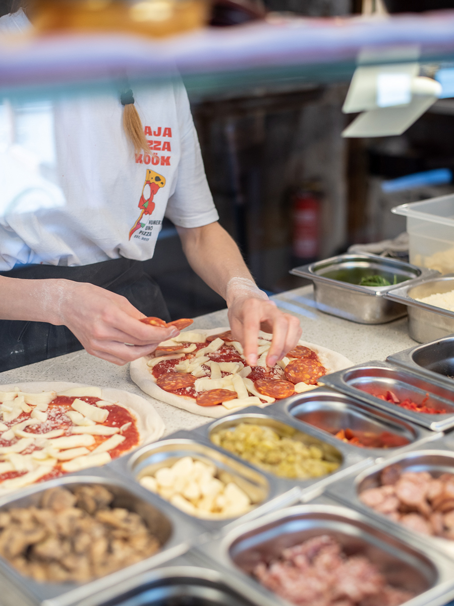 Mitarbeiterin beim Belegen mehrerer neapolitanischer Pizzen im Kaja Pizza Köök in Tallinn
