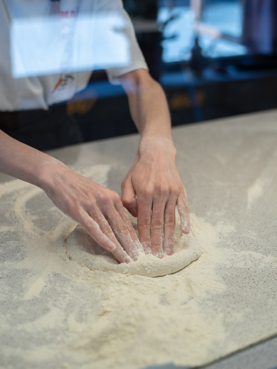 Hände beim Formen eines Pizzateigs im Kaja Pizza Köök in Tallinn