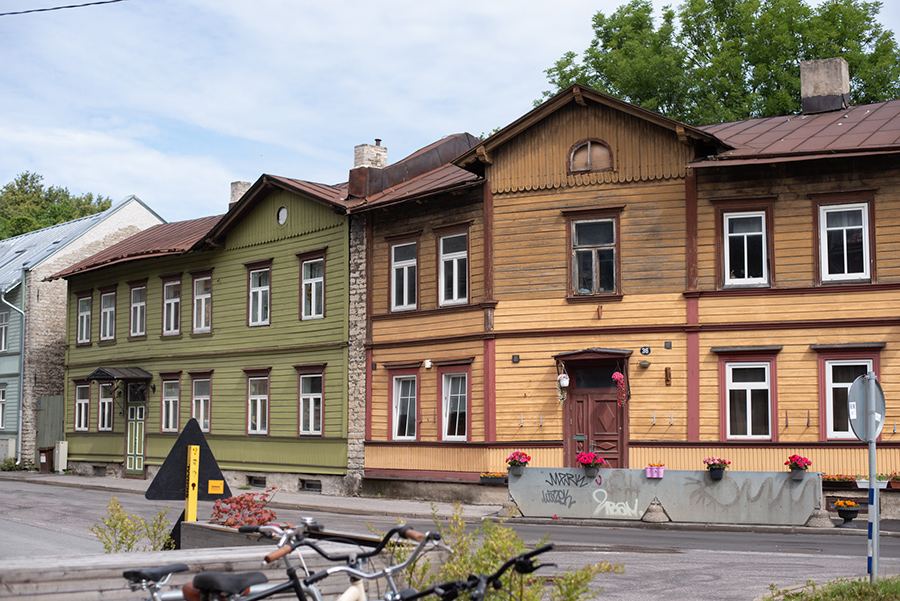 Reihe historischer, farbig gestrichener Holzhäuser an einer Straße im Tallinner Stadtteil Kalamaja
