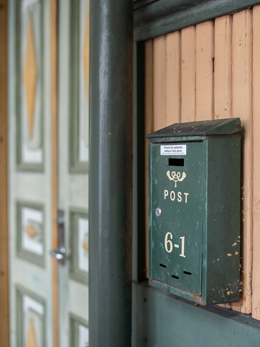 Grüner Briefkasten mit Hausnummer 61 an einer alten Holztür in Kalamaja in Tallinn