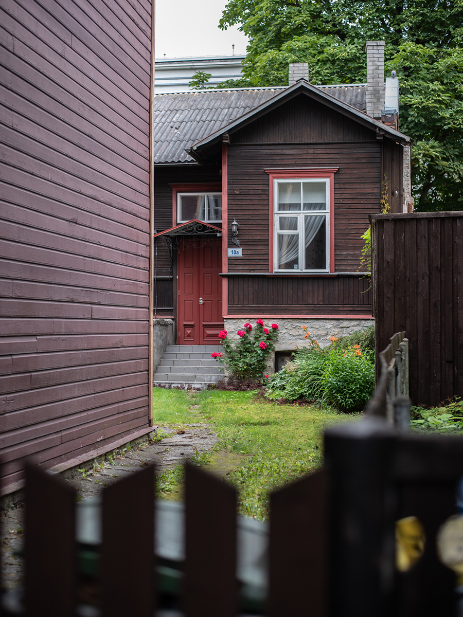 Kleines rotes Holzhaus in einem begrünten Hinterhof im Tallinner Stadtteil Kalamaja