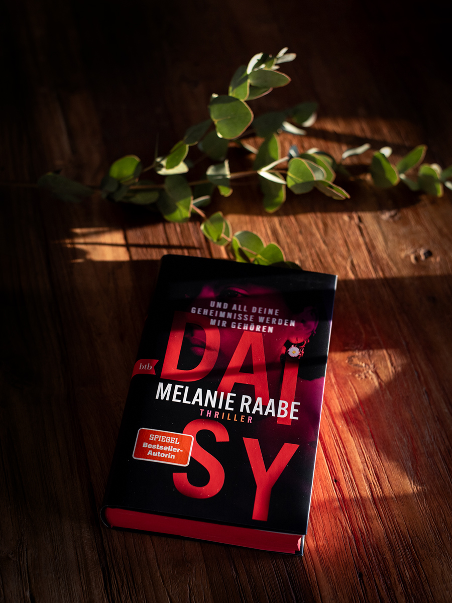 Daisy von Melanie Raabe auf einem Tisch neben Blumen