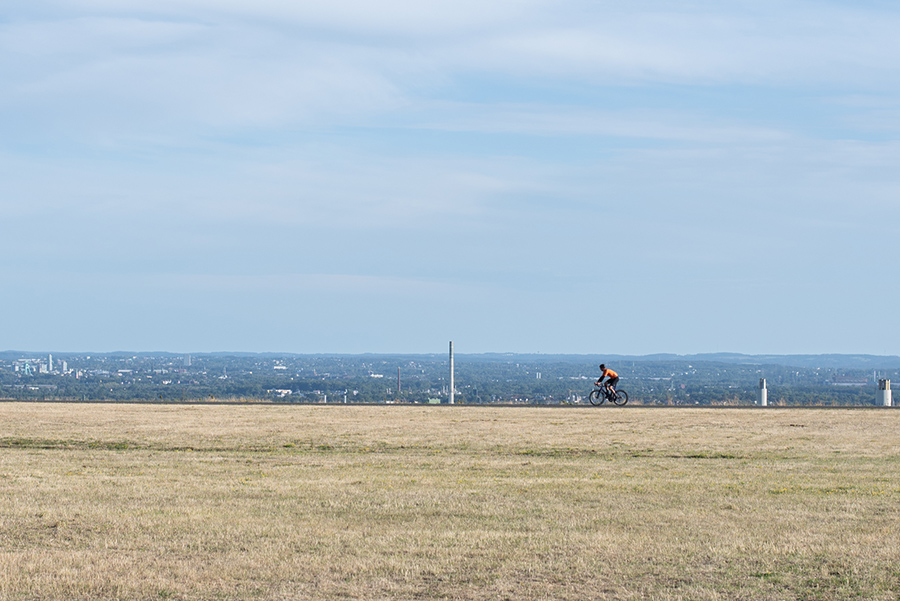 Radfahrer auf der Halde Hoheward vor weitem Horizont