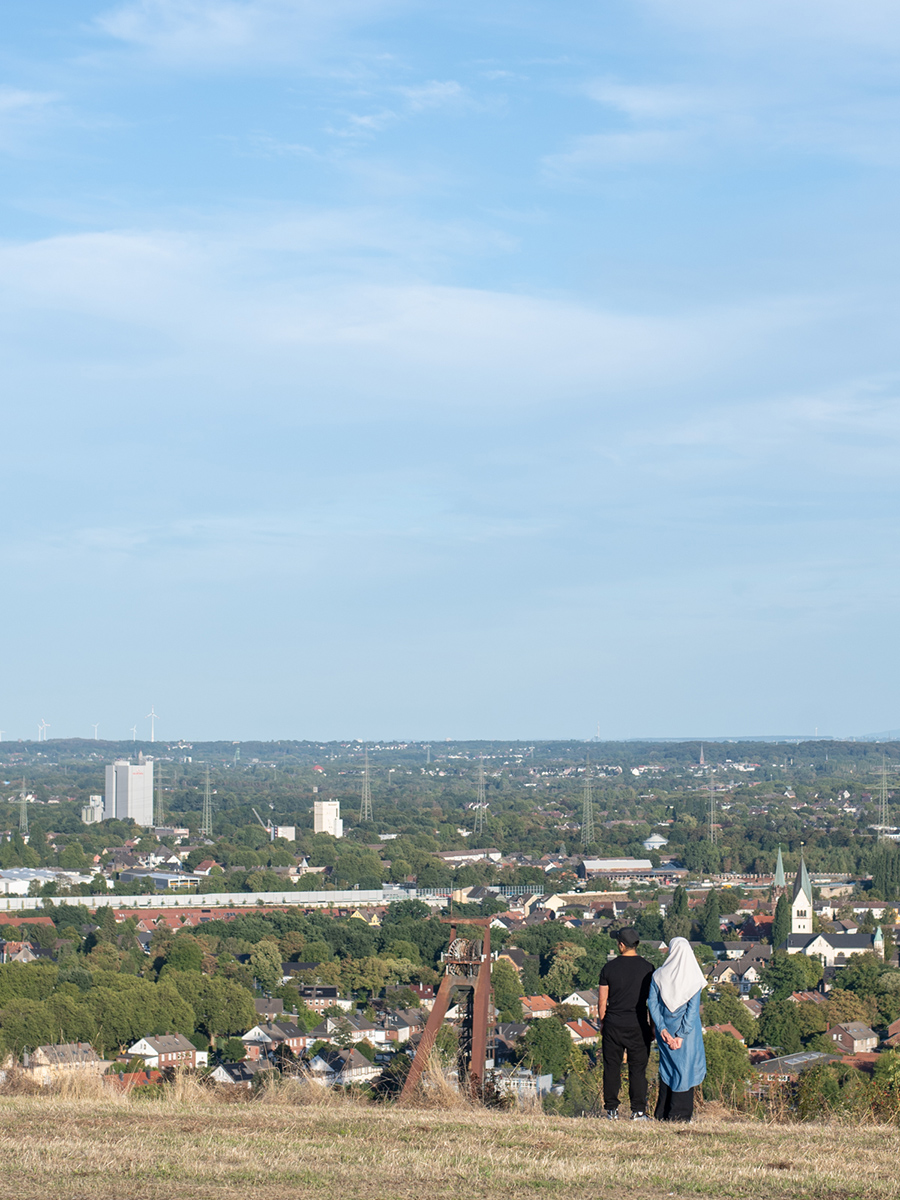 Zwei Menschen blicken von der Halde Hoheward Richtung Zeche Recklinghausen II