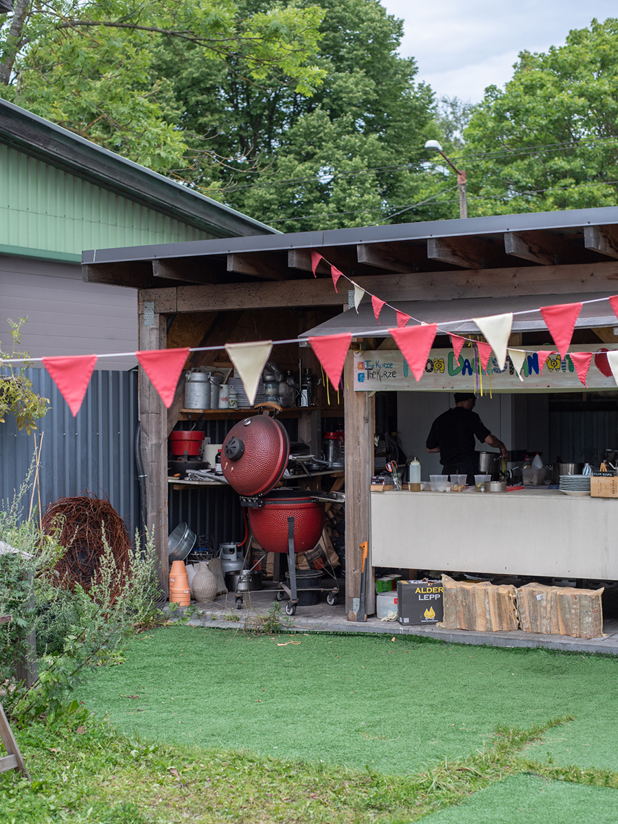Offene Außenküche des Restaurants The Kurze in Tallinn mit roten Wimpeln