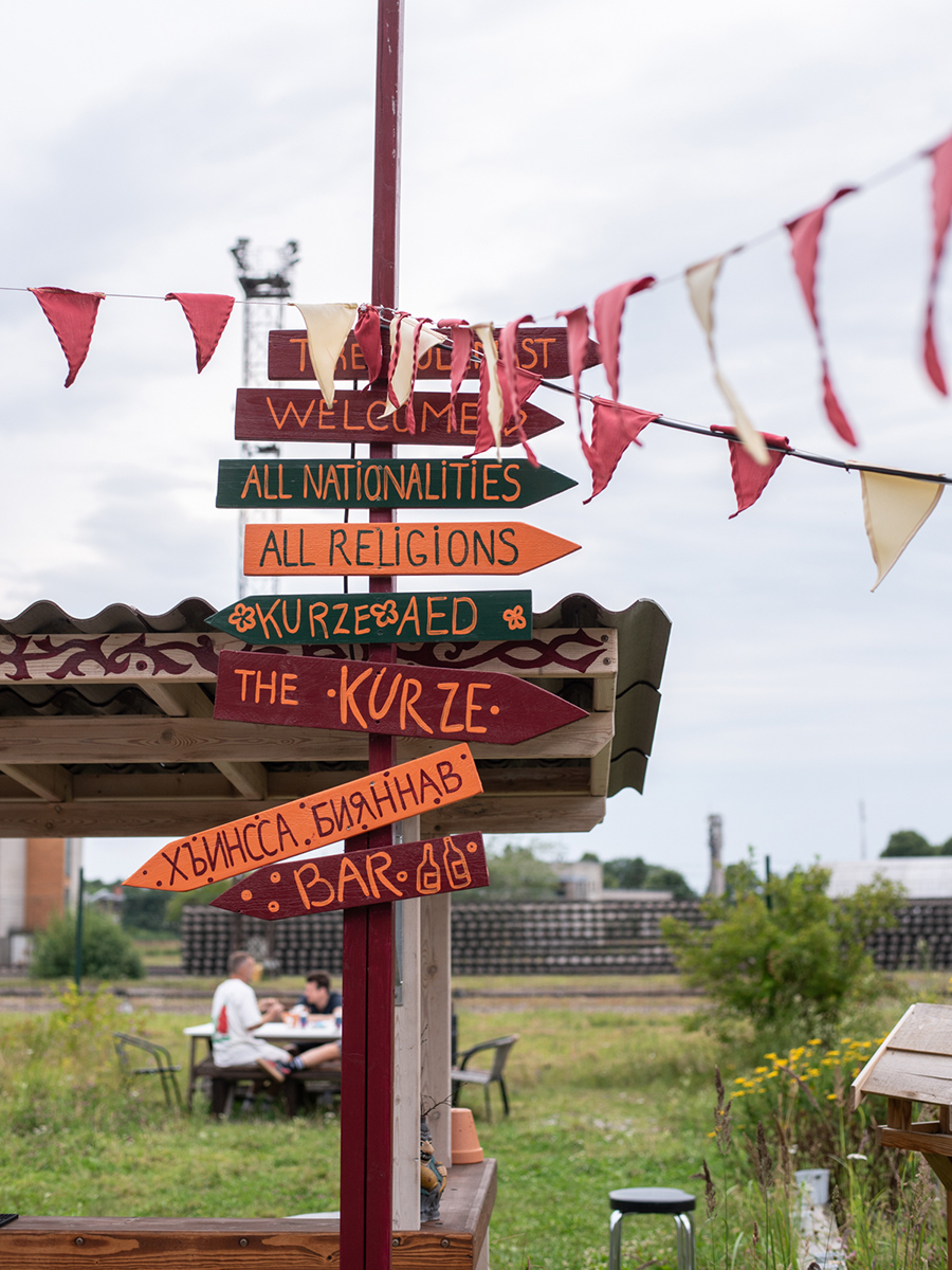 Bunte Wegweiser und Wimpel im Garten des Restaurants The Kurze in Tallinn